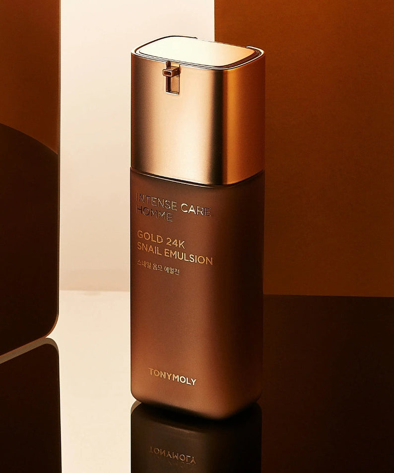 TONYMOLY Intense Care Gold 24K Snail Homme Emulsion 130ml, bouteille dorée sur fond beige et noir.