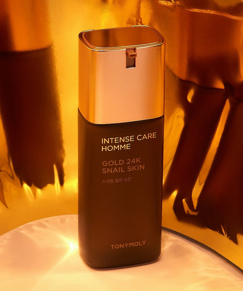 TONYMOLY Intense Care Gold 24K Snail Homme Skin 130ml : flacon doré en contexte luxe, lumière chaude.
