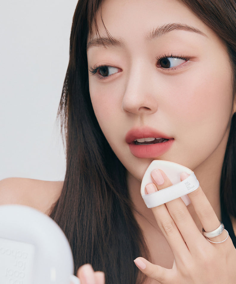TOO COOL FOR SCHOOL Fixing Cover Fit Cushion [Product + Refill] : femme appliquant le cushion sur le visage, studio clair.