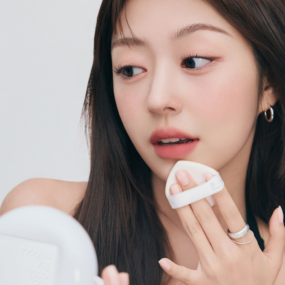 TOO COOL FOR SCHOOL Fixing Cover Fit Cushion [Product + Refill] : femme appliquant le cushion sur le visage, studio clair.