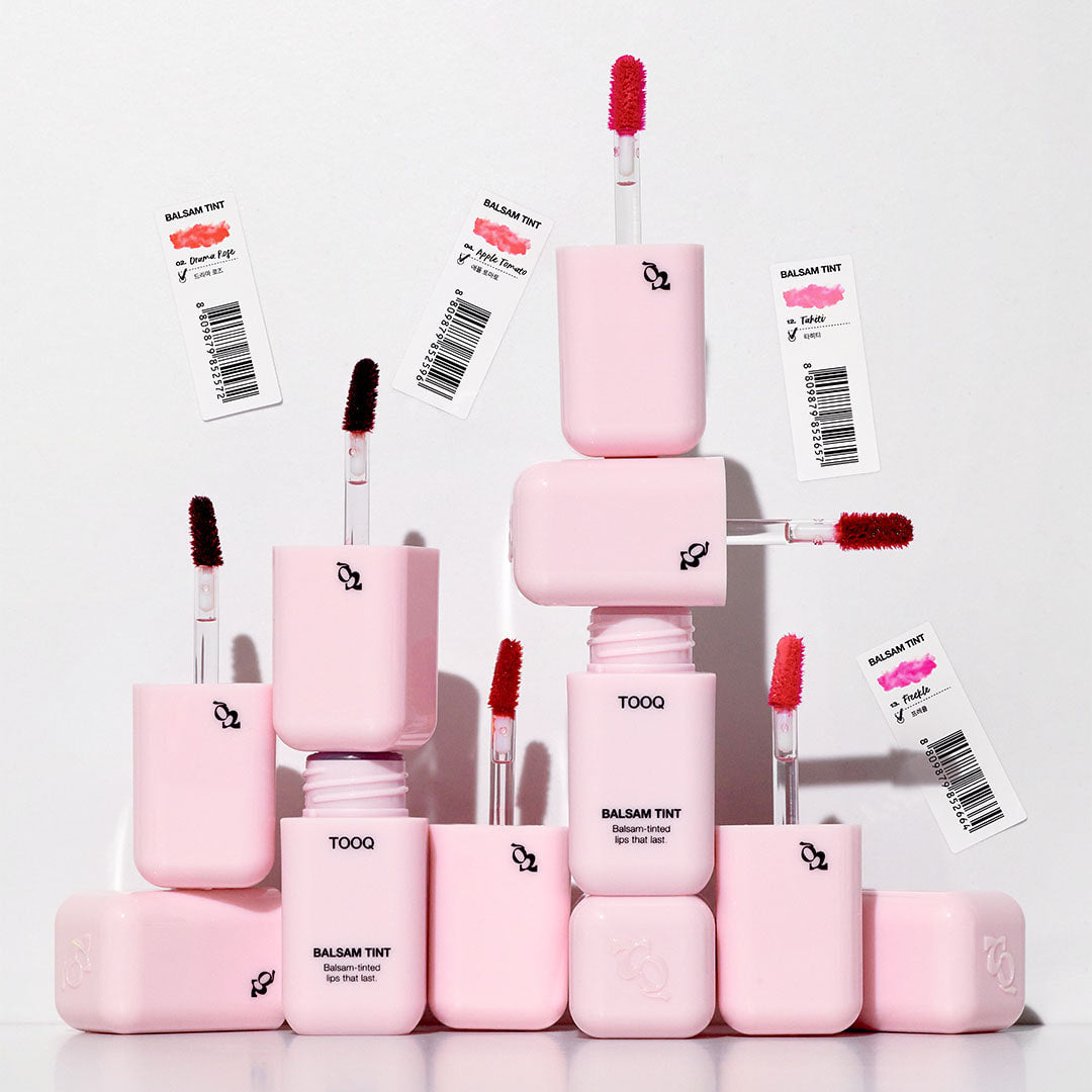 TOOQ Balsam Tint de la marque TOOQ, tubes roses de maquillage sur fond blanc, photo produit en studio.