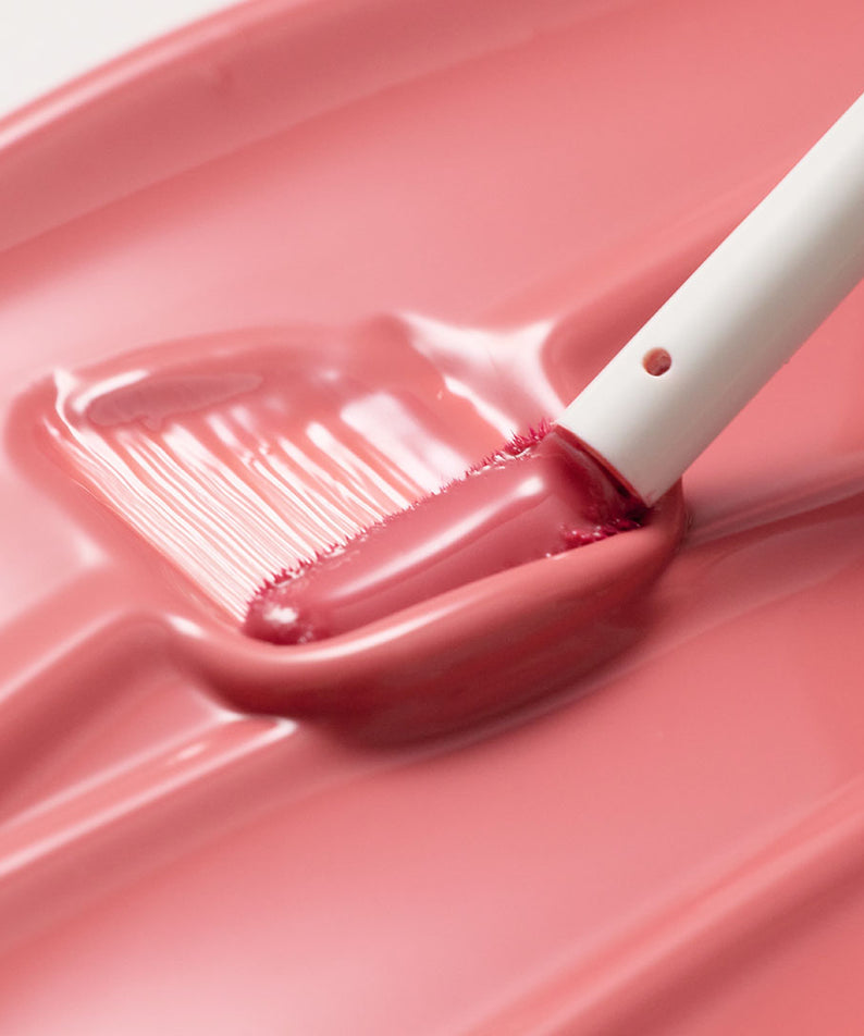 Applicateur du TOOQ Gentle Kiss Glow Tint rose crémeux, texture lissante pour lèvres éclatantes.