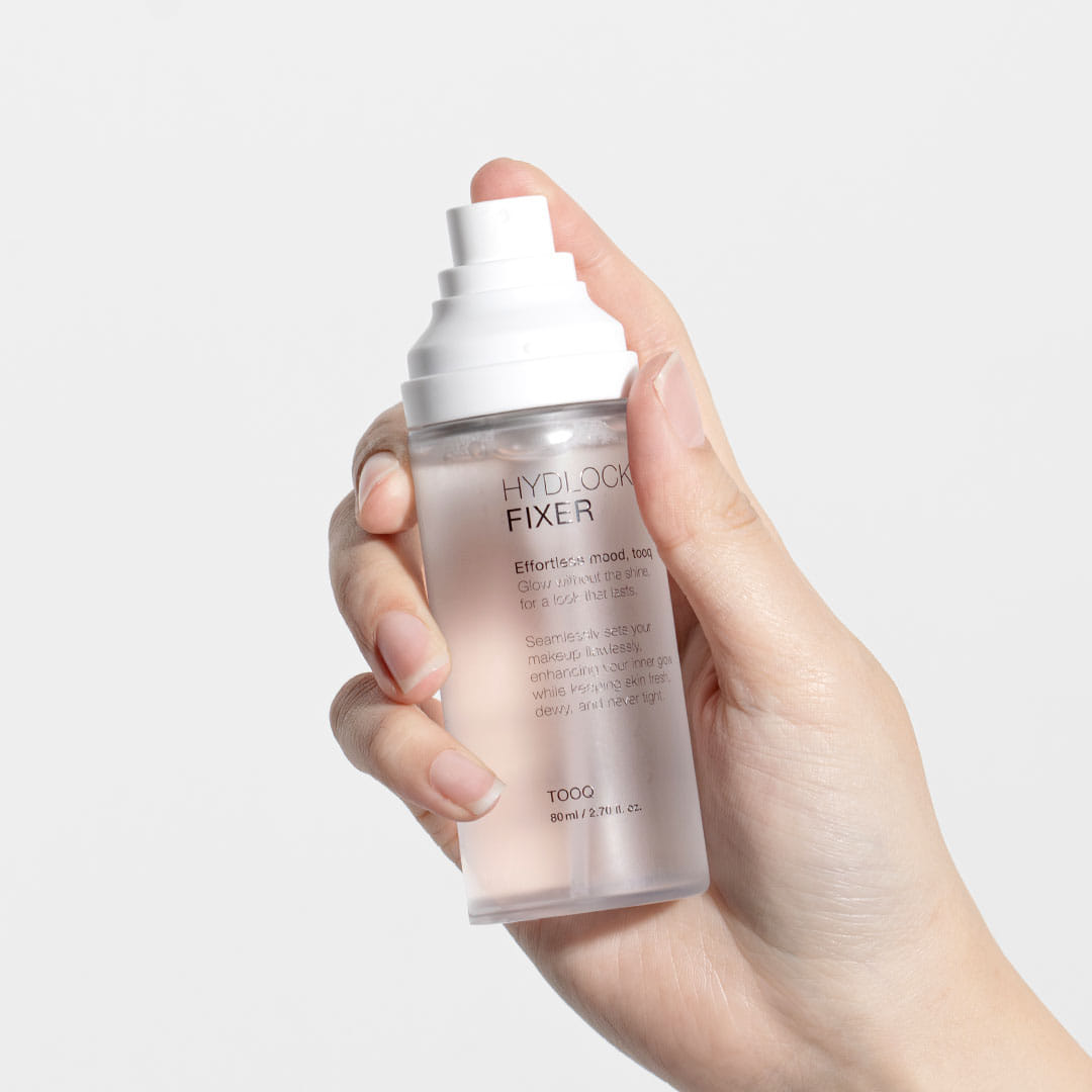 TOOQ Hydrock Fixer 80ml de la marque TOOQ, flacon tenu en main sur fond blanc, produit cosmétique.