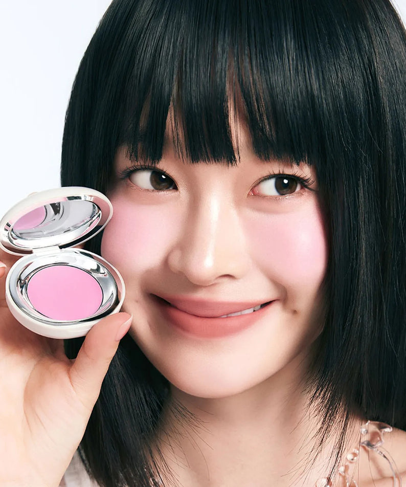 TOOQ Satin Peach Blossom : la marque TOOQ, maquillage en poudre rose pêche sur fond clair, visage souriant tenant le produit