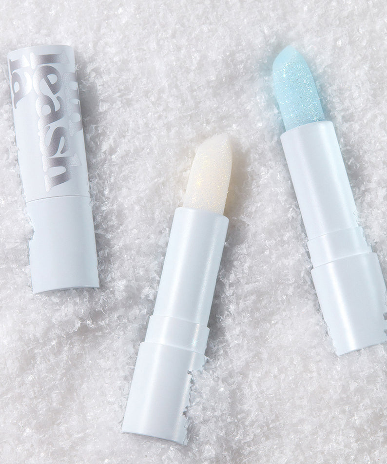 Baumes à lèvres UNLEASHIA Glacier Vegan avec texture glacée sur fond de neige, soins naturels et hydratation labiale intense.
