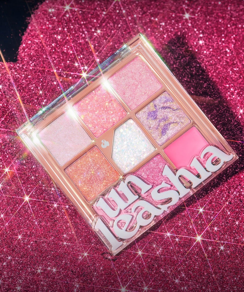 UNLEASHIA Glitterpedia Eye Palette de UNLEASHIA sur fond pailleté rose, palette d’ombres aux teintes irisées.