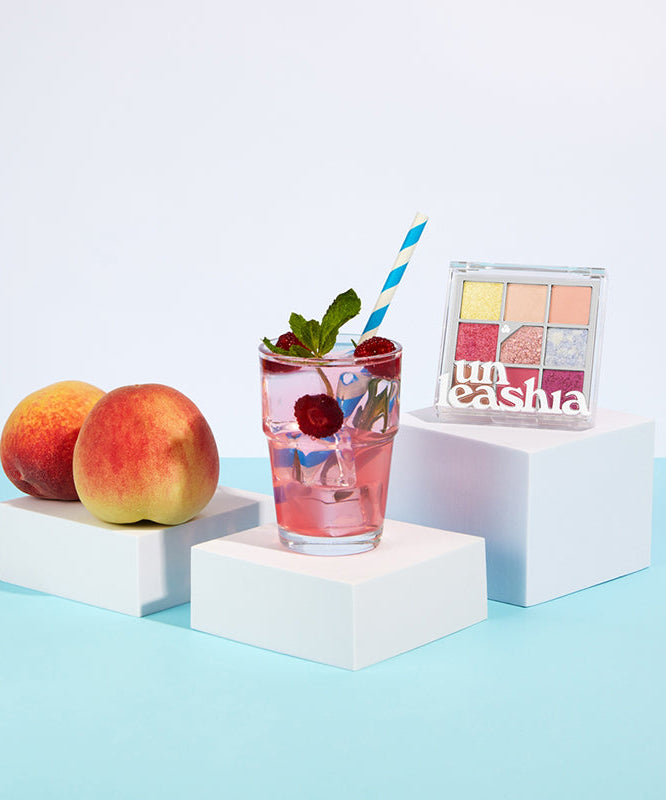 UNLEASHIA Glitterpedia Eye Palette de la marque UNLEASHIA, packaging maquillage sur cubes blancs, décor fruits et cocktail.