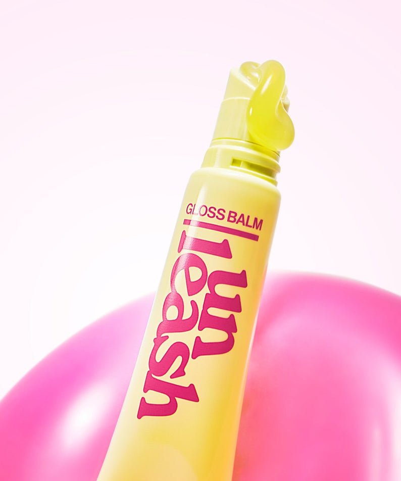 Baume scintillant UNLEASHIA Sunset Dazzle Gloss Balm en gros plan, couleur jaune vif avec des détails rose.