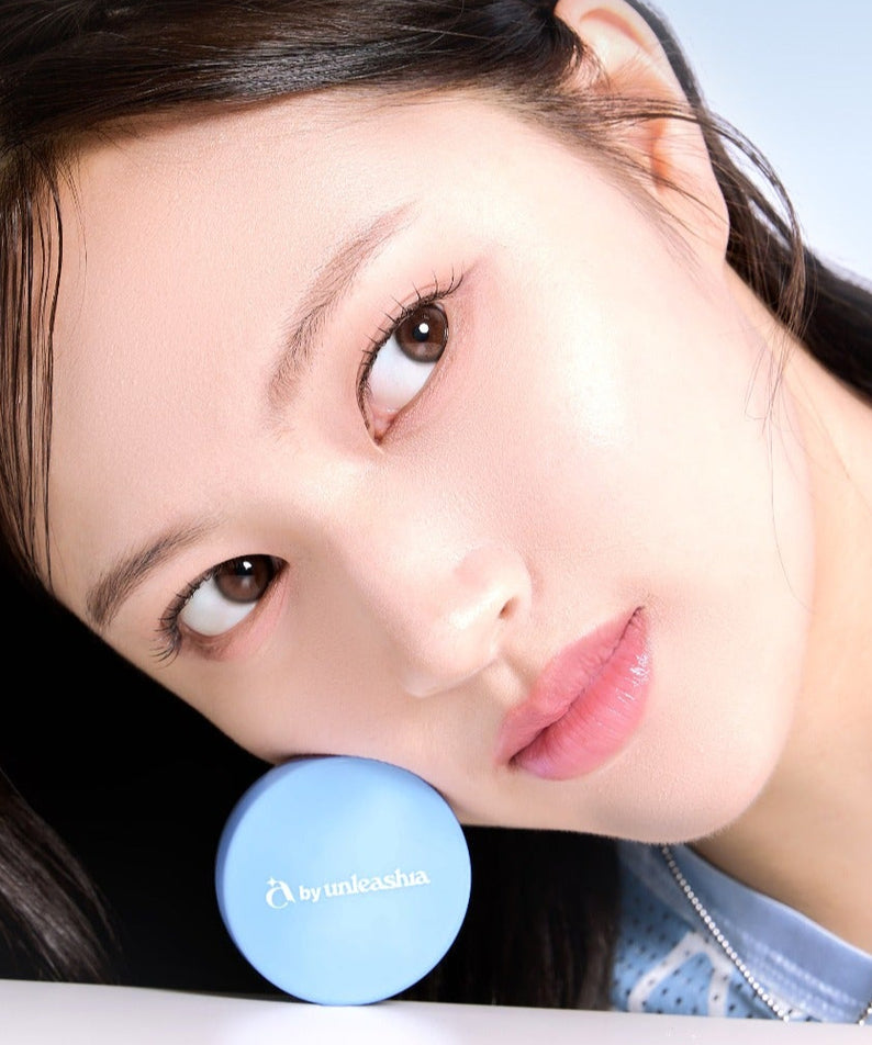 Produit UNLEASHIA Be Be Blue Cushion avec une femme en gros plan affichant un teint lumineux grâce au coussin cosmétique.