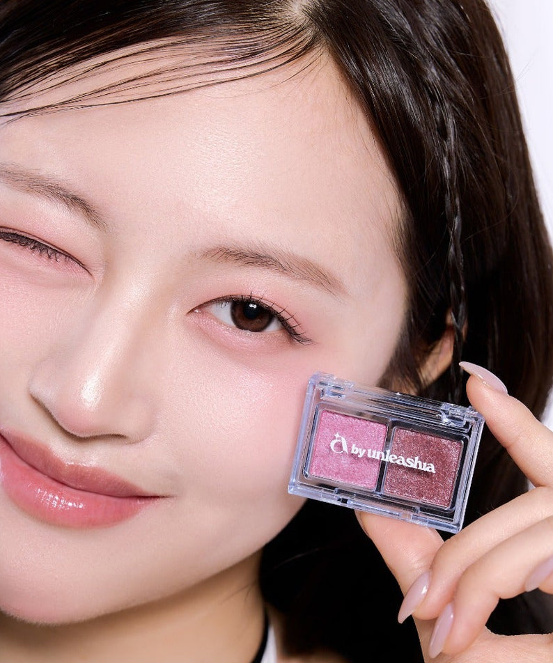 Femme souriante tenant la UNLEASHIA Cotton Candy Face Palette, maquillage frais et éclatant sur le visage.