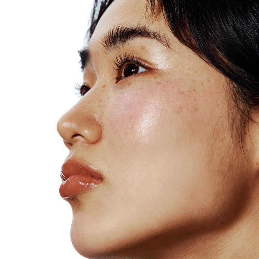 UNLEASHIA Sisua Berry Shot Lip Tint, gros plan sur lèvres teintées baies, portrait maquillage sur fond clair.