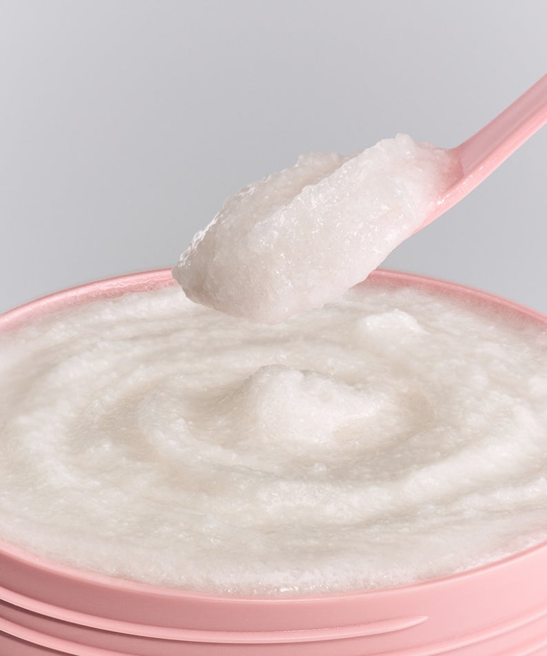 UNOVE Anove Glow Creamy Body Scrub 300g — texture crémeuse sur cuillère, contexte visuel produit beauté, marque UNOVE