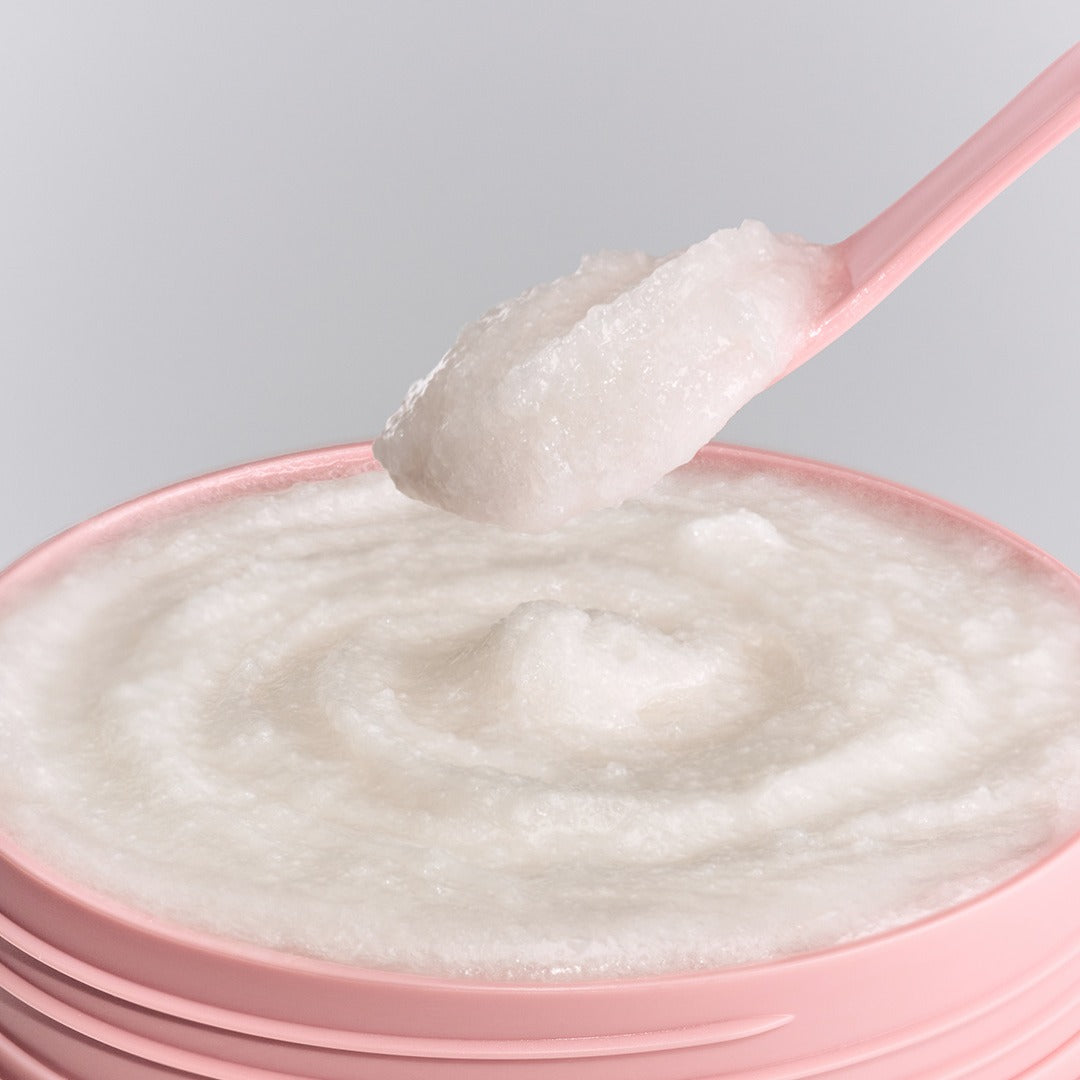 UNOVE Anove Glow Creamy Body Scrub 300g — texture crémeuse sur cuillère, contexte visuel produit beauté, marque UNOVE