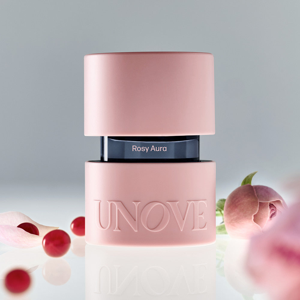 UNOVE Eau De Parfume UNOVE, flacon rose « Rosy Aura » sur fond doux avec fleurs et baies, image produit