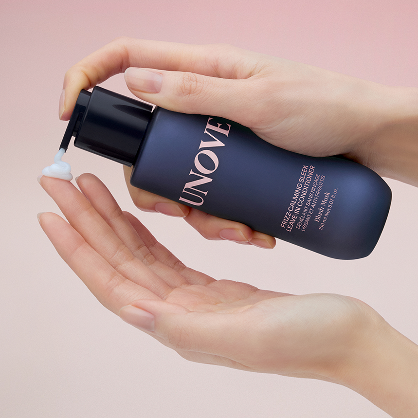 UNOVE Frizz Calming Sleek Leave-In Conditioner 150ml en main, produit UNOVE sur fond rose pastel, texture crème