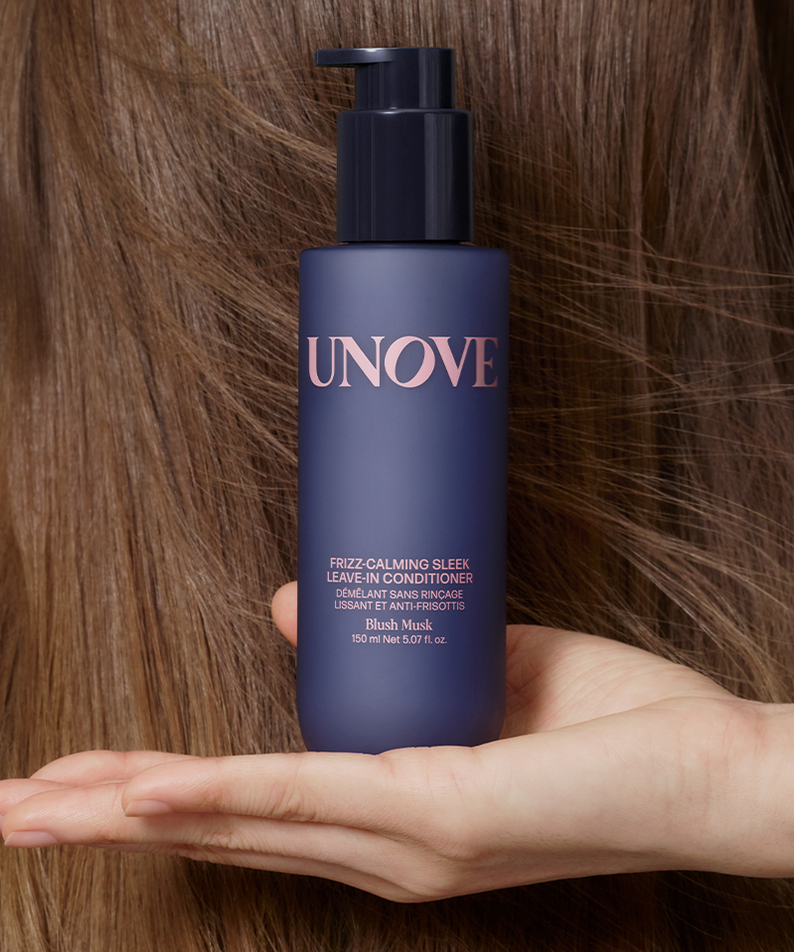 UNOVE Frizz Calming Sleek Leave-In Conditioner 150ml de la marque UNOVE, flacon bleu sur fond cheveux, mains tenant le produit