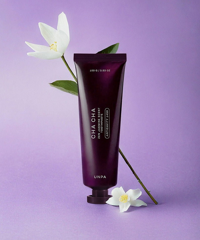 Décris l'image en français en mentionnant le produit, la marque et le contexte visuel : UNPA Cha CHa Zen Jasmine Scent 1450 High Fluoride Toothpaste 100g