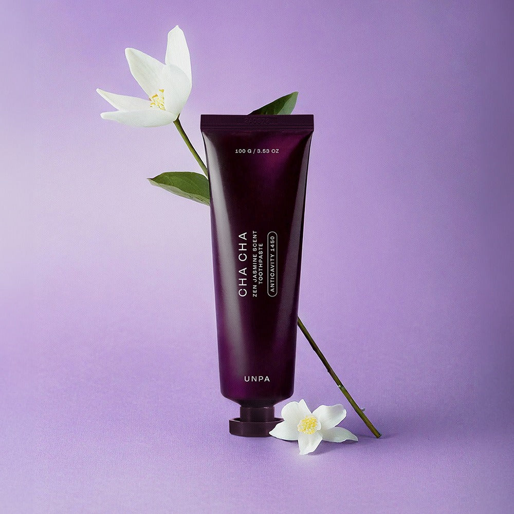 Décris l'image en français en mentionnant le produit, la marque et le contexte visuel : UNPA Cha CHa Zen Jasmine Scent 1450 High Fluoride Toothpaste 100g