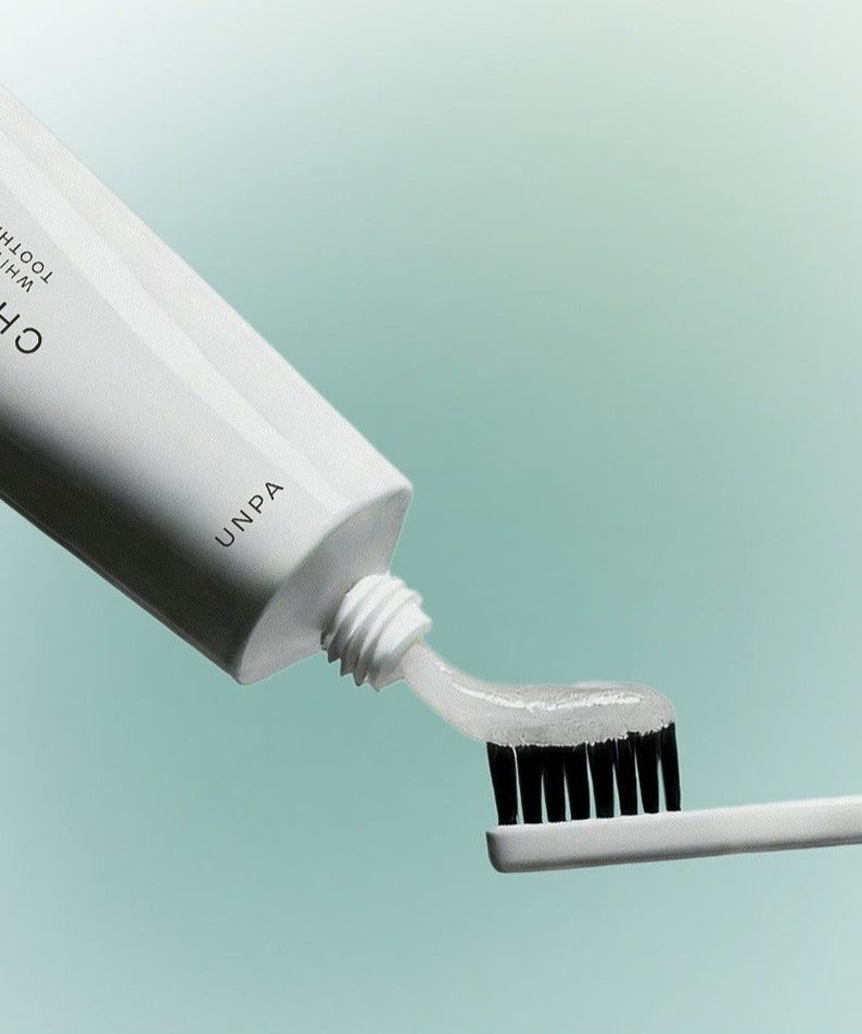 UNPA Chacha French Chamomile Vegan Whitening Toothpaste 90g, UNPA, tube et brosse sur fond bleu clair, style produit.