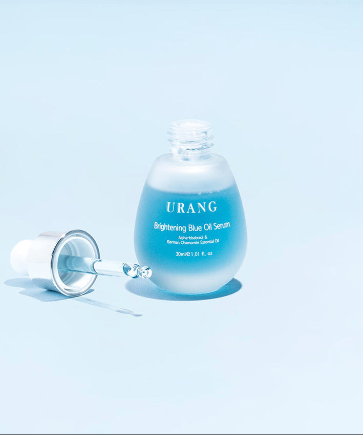 Flacon de s 9frum URANG Brightening Blue Oil Serum 30ml sur fond bleu clair