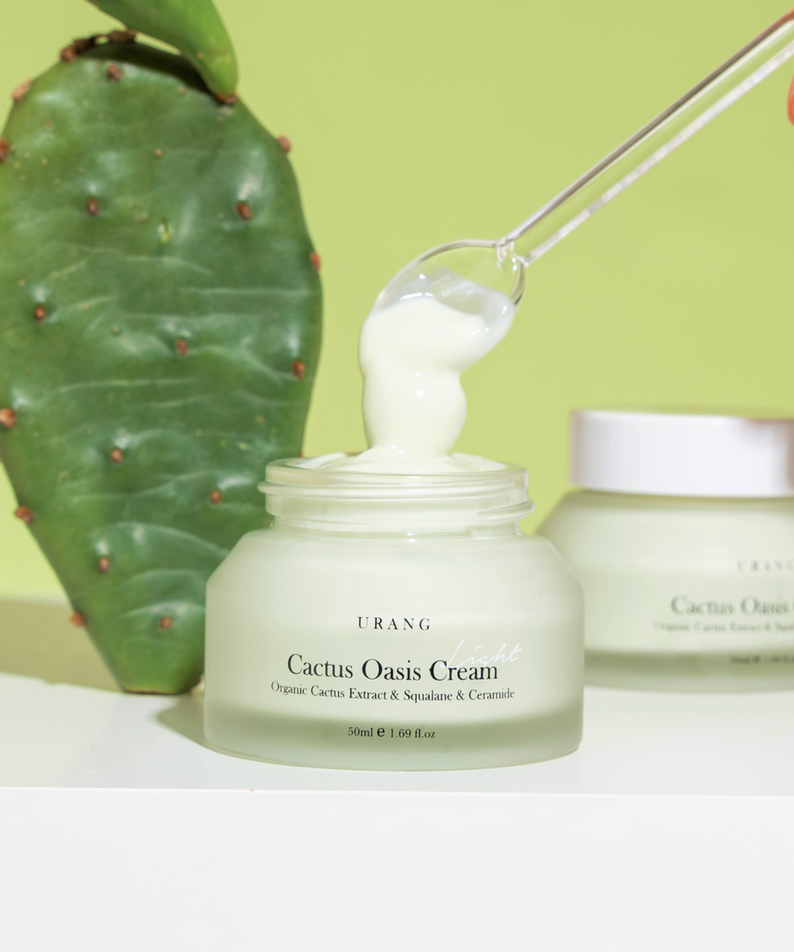 Crème hydratante URANG Cactus Oasis Cream 50ml avec extrait de cactus, vue avec plante, texture lisse et fond vert.
