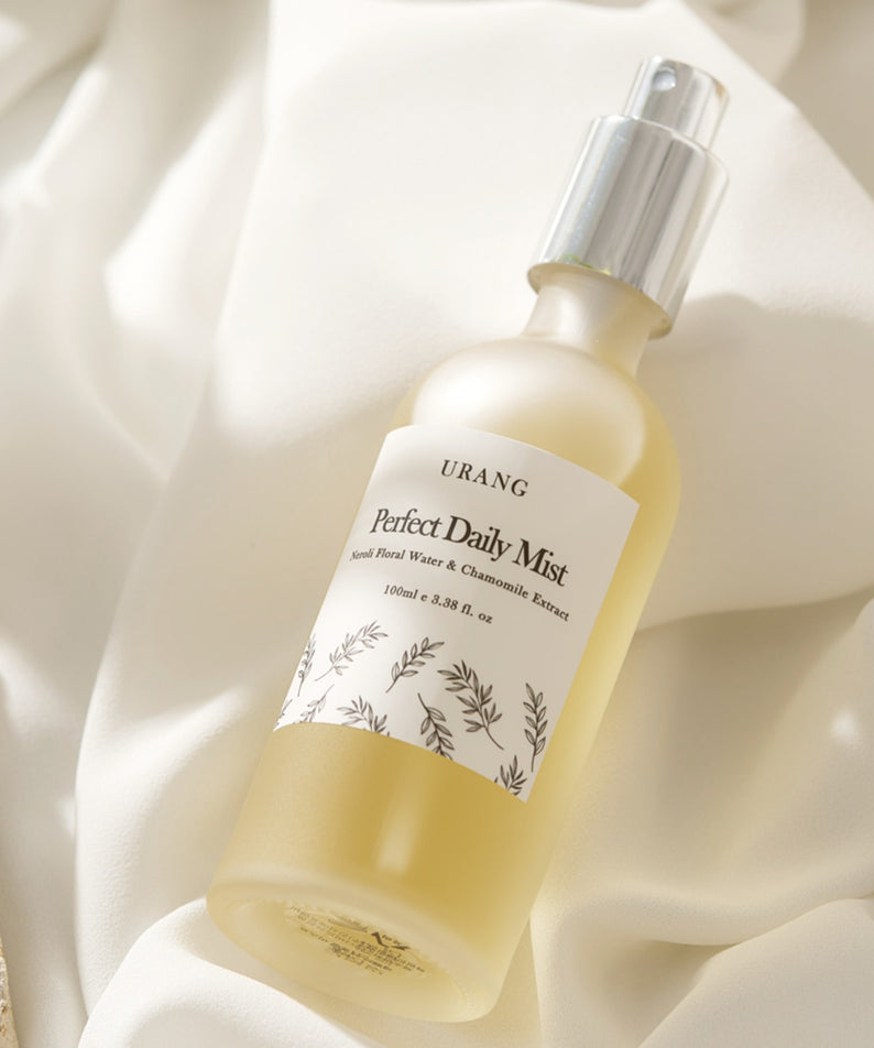 URANG Perfect Daily Mist 100ml sur fond de tissu blanc luxueux, vaporisateur rafraîchissant pour une hydratation quotidienne.