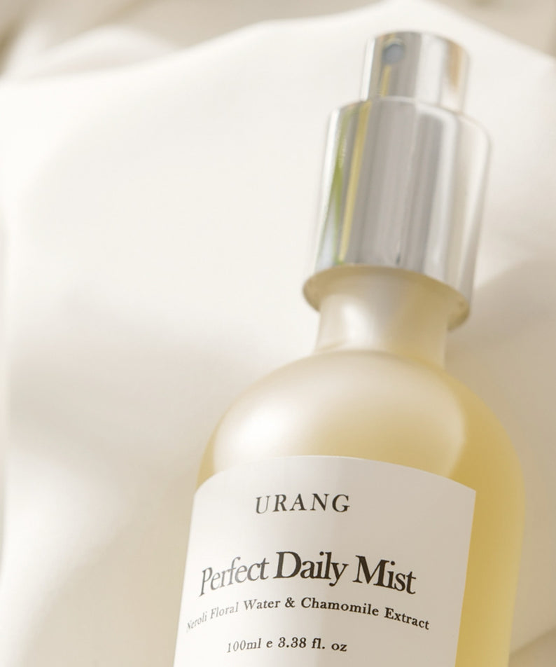 Vaporisateur de beauté URANG Perfect Daily Mist 100ml sur fond beige élégant, produit essentiel pour une routine éclatante.