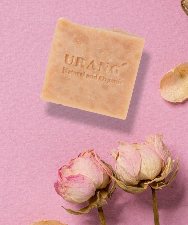 Savon artisanal URANG Rose Garden CP avec fleurs en fond rose.