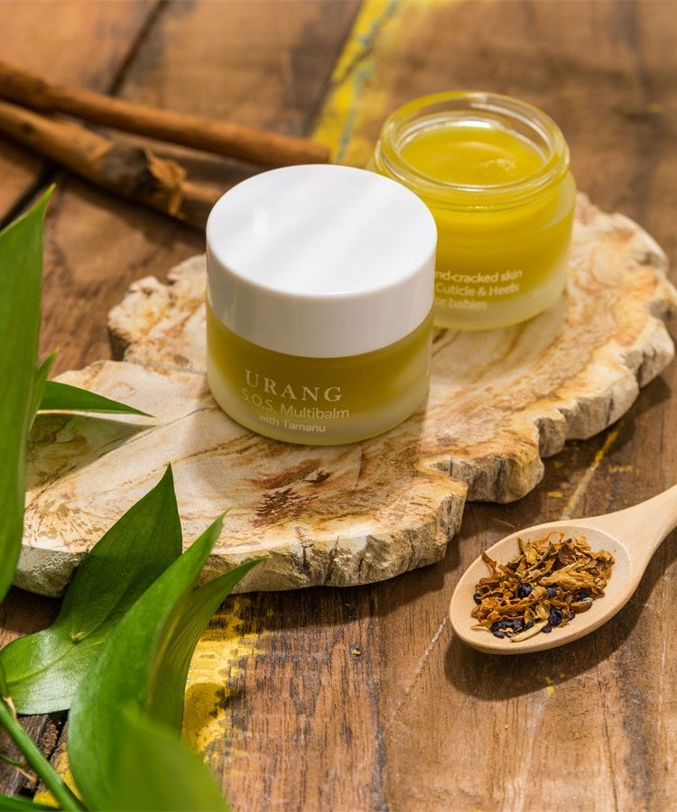 URANG SOS Multi Balm sur une planche en bois avec des ingrédients naturels, soin hydratant pour la peau sèche.