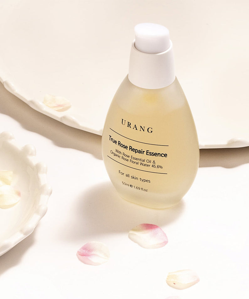 URANG True Rose Repair Essence sur fond de pétales de rose, produit de soin de la peau naturel.