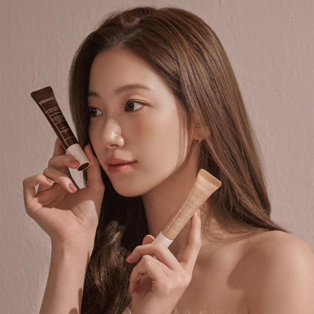 VIDIVICI Peptide Butter Tint Balm, maquillage sur fond beige : mannequin tenant le baume teinté, marque visible