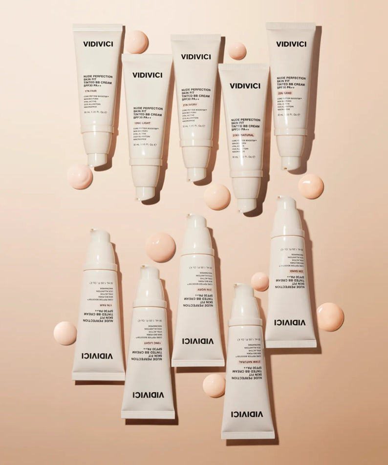 Collection de VIDIVICI Nude Perfection Skin Fit Tinted BB Cream SPF30 PA++ 30ml sur fond beige avec des gouttes de crème.