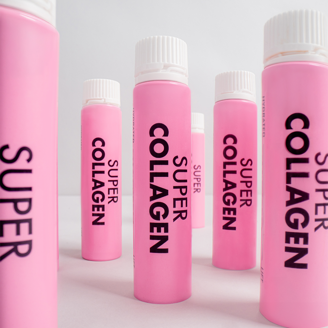 VITAL BEAUTIE Super Collagen 28 Tablets, bouteilles roses alignées sur fond blanc, branding visible.