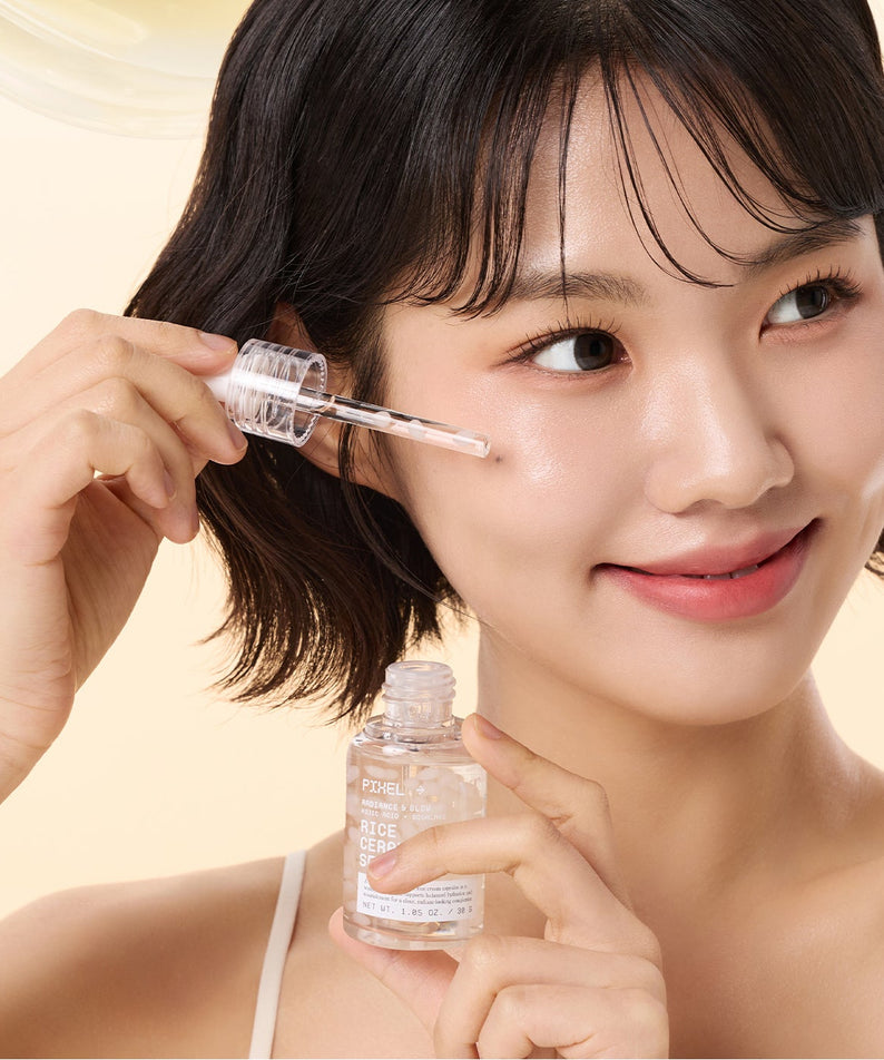 Décris l'image en français : VT COSMETIC Rice Ceramide Serum 30ml, marque VT, sur flacon et pipette près du visage d’une femme.