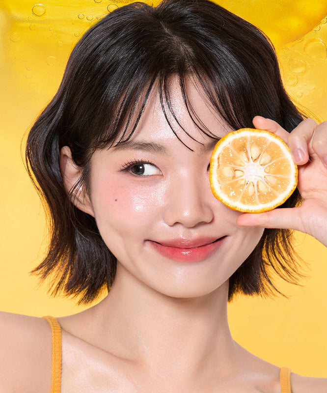VT COSMETIC Vitamin C Astaxanthin Serum 30ml : flacon VT COSMETIC, femme tenant une tranche d’orange sur fond jaune
