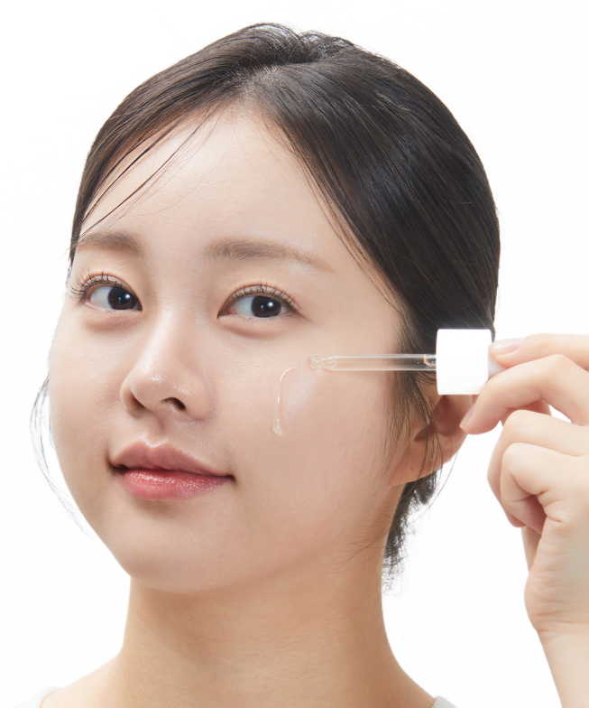 VT COSMETICS  G2 Glutathione Brightening Ampoule 30ml, sérum éclaircissant; la femme applique le produit sur le visage.