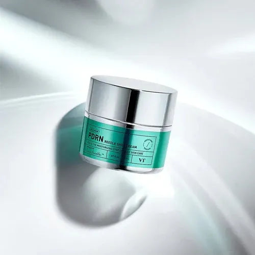 VT COSMETICS PDRN Riddle Shot Cream 50ml de VT Cosmetics sur fond blanc, flacon vert et argent en lumière douce.