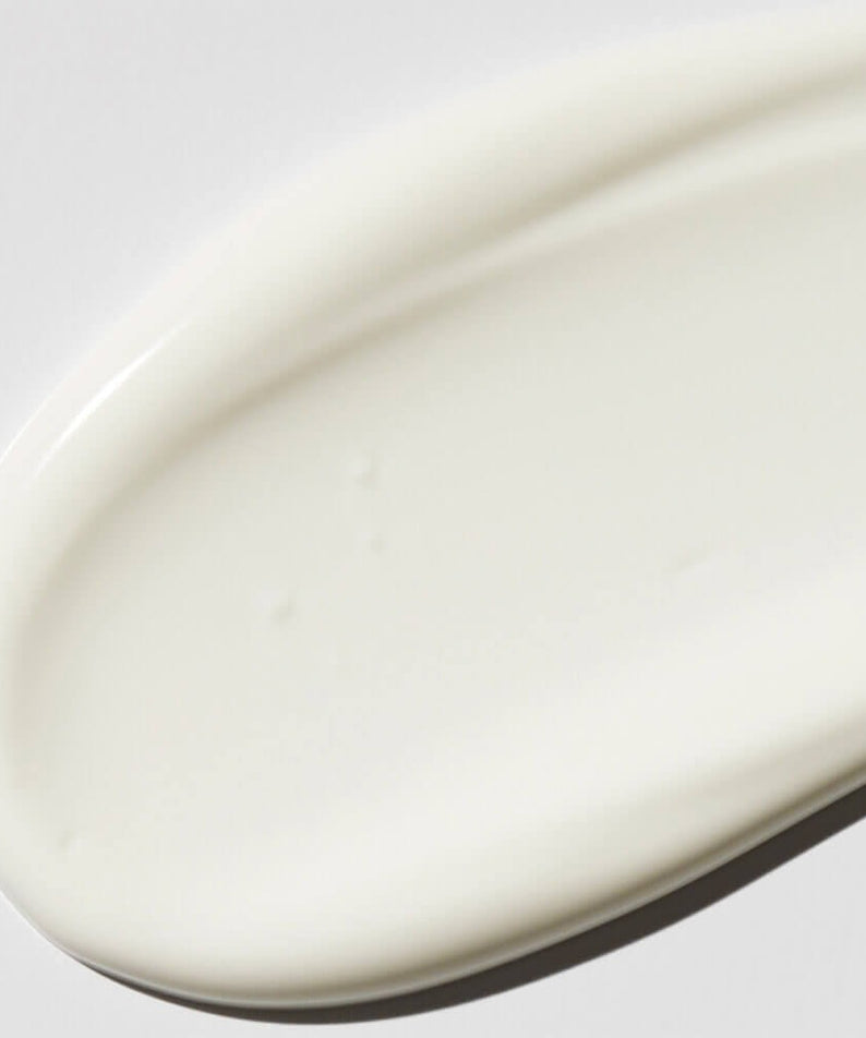 Texture de VT COSMETIC PDRN Moist Tone-Up Sun Essence RX 60ml sur fond blanc, crème hydratante pour la peau.