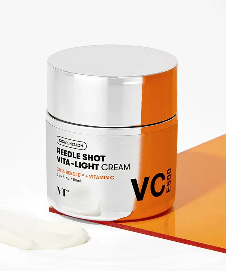 VT COSMETIC Riddle Shot Vita-Light Cream 50ml avec vitamine C sur fond blanc, pot argenté et orange, crème hydratante lumineuse.