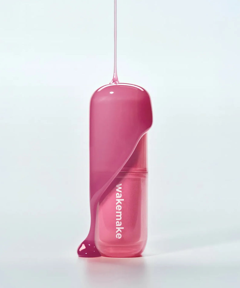 WAKE MAKE Waterfull Glow Tint 4.6g avec texture liquide rose brillante sur fond blanc.