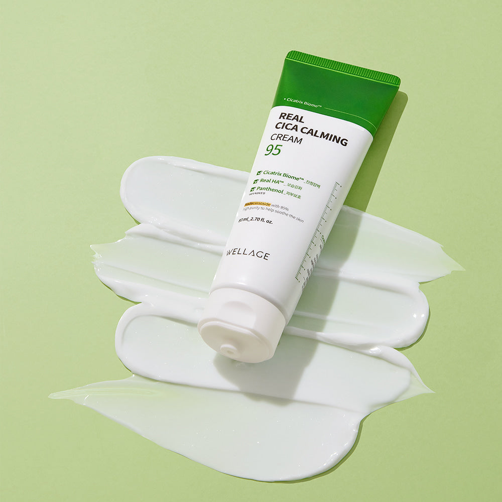 WELLAGE Real Cica Calming 95 Cream 80ml sur crème blanche, flacon WELLAGE et contexte vert en studio