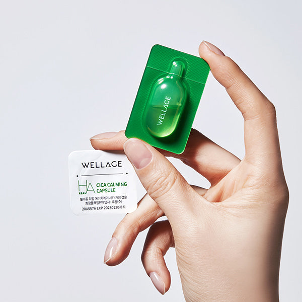 Main tenant WELLAGE Real Cica Calming One Day Kit de WELLAGE, capsules Cica Calming sur fond clair, packaging vert
