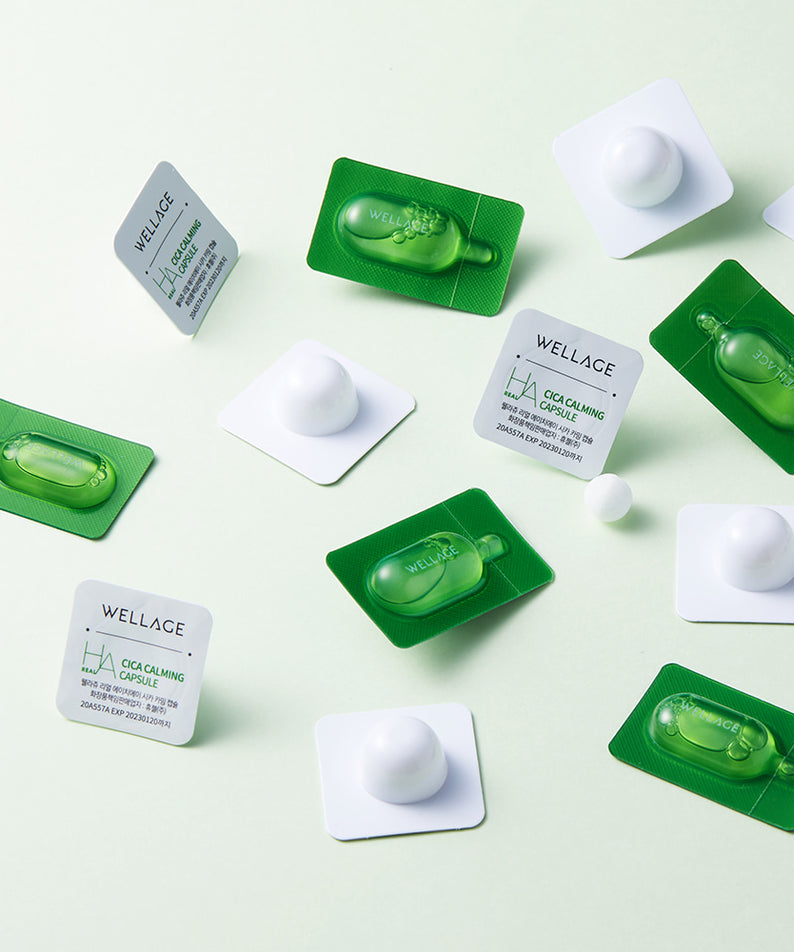 Décris l'image en français : WELLAGE Real Cica Calming One Day Kit de la marque WELLAGE, plaquettes vertes et boîtes sur fond clair