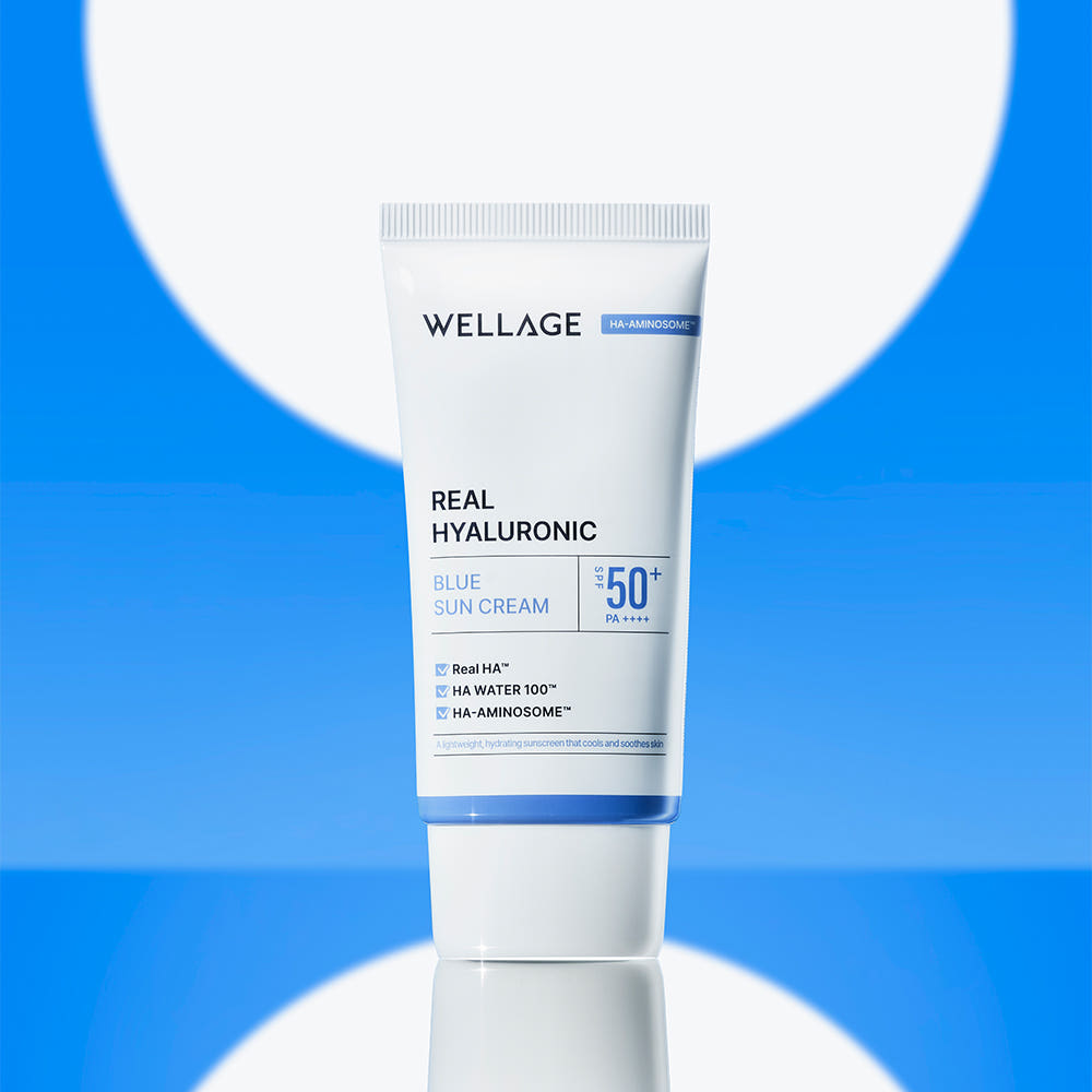WELLAGE  Real Hyaluronic Blue Sunscreen 50ml, tube crème solaire sur fond bleu et blanc, marque visible.