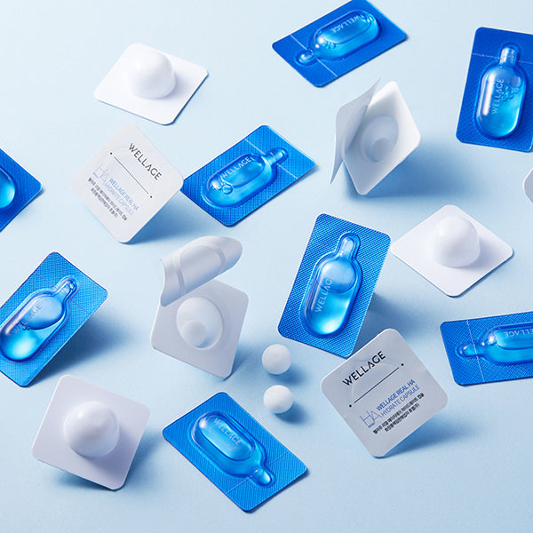 Décris l'image : WELLAGE Real Hyaluronic One Day kit de la marque WELLAGE, blister et produits sur fond bleu clair.