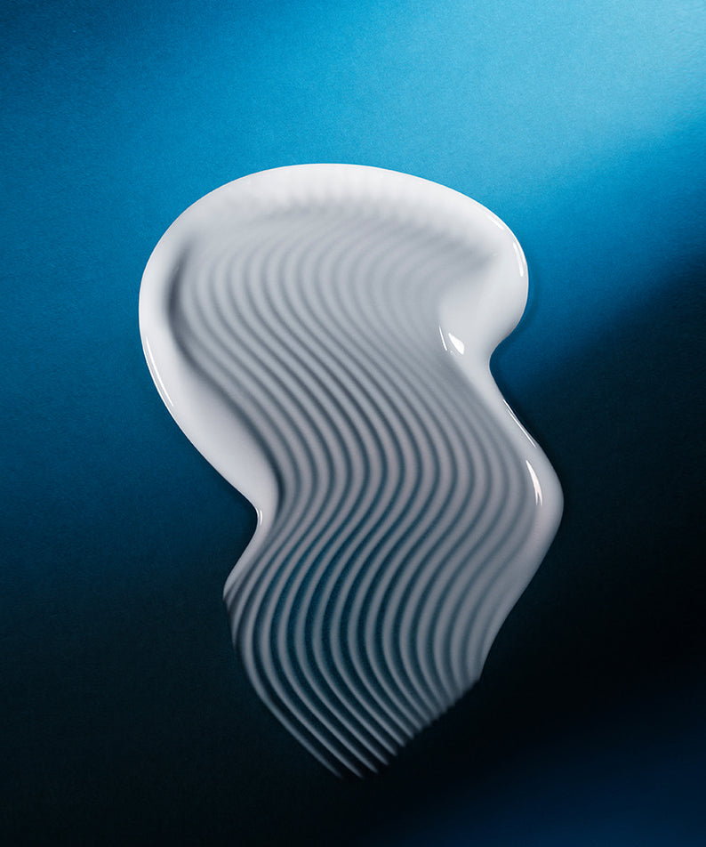 Texture de WELLAGE Hyper Peptide Bandage Cream 50ml sur fond bleu, illustrant sa formule unique et onctueuse.