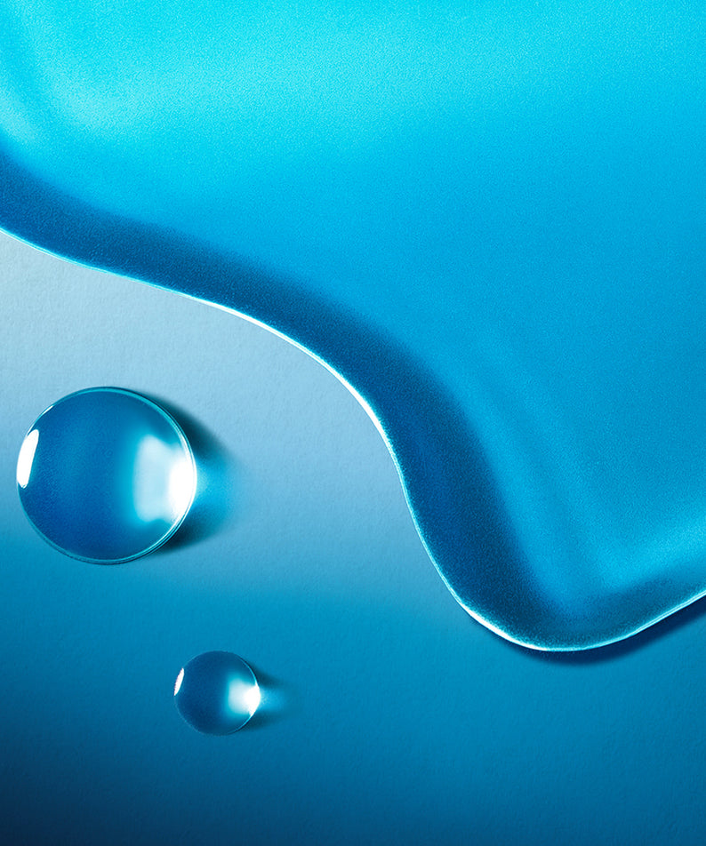 Texture du TONER REVITALISANT WELLAGE Hyper eptide Skin booster 200ml avec des gouttes de liquide bleu sur fond lumineux.