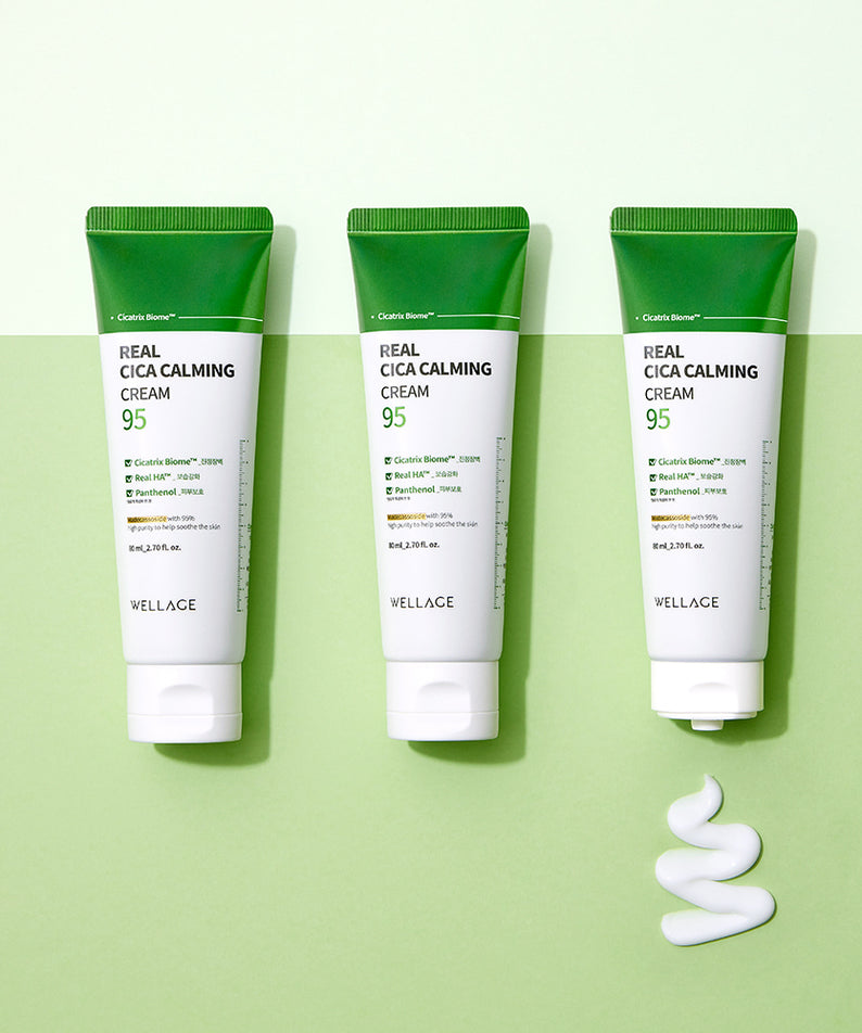 Trois tubes de WELLAGE Real Cica Calming 95 Cream 80ml sur fond vert avec texture de crème déposée.