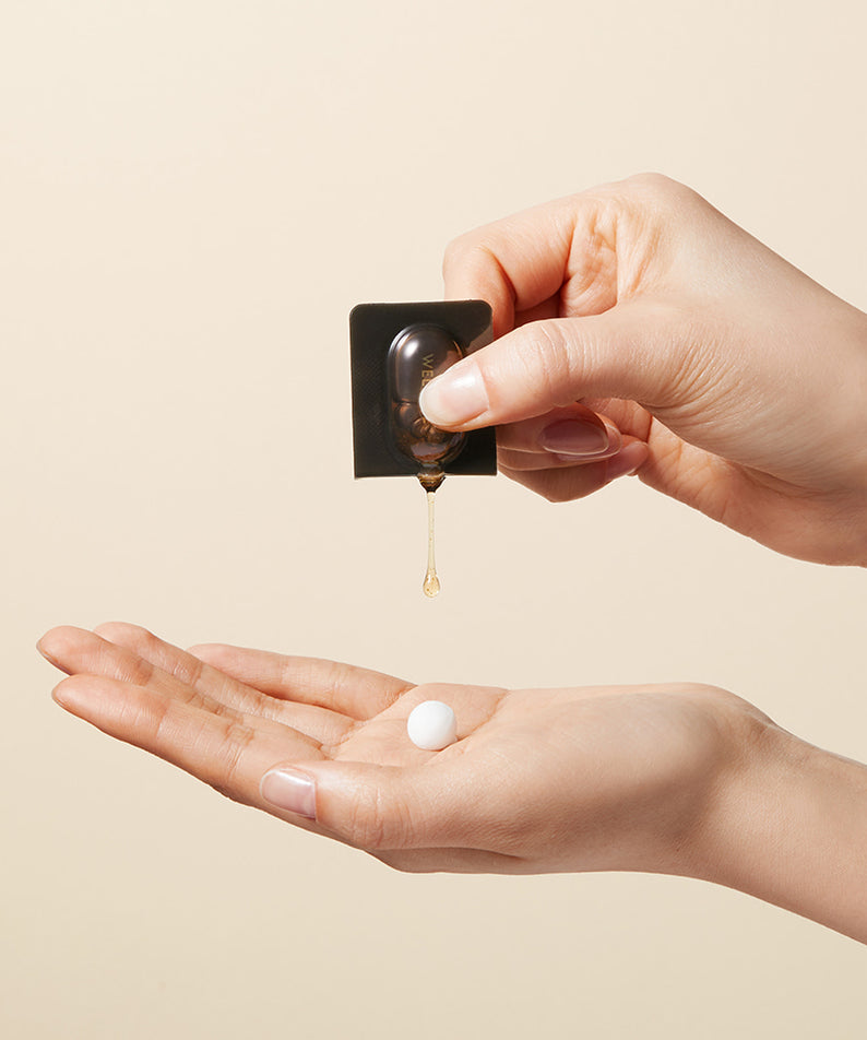 Produit de soin WELLAGE Real Gold Collagen One Day Kit appliqué sur la main pour une peau éclatante.