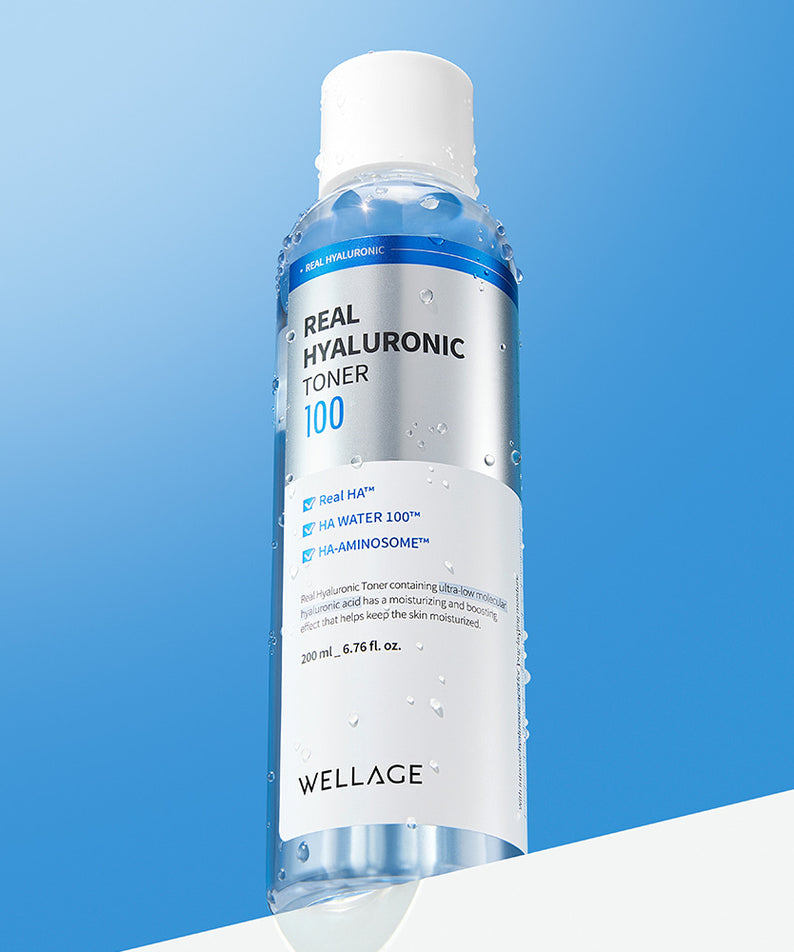 Flacon de WELLAGE Real Hyaluronic 100 Toner 200ml sur fond bleu, contenant des gouttelettes de condensation.